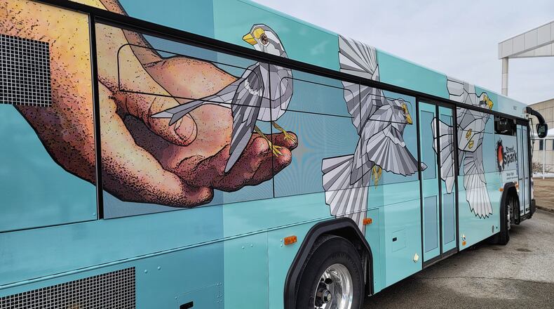 Three Butler County Regional Transit Authority buses have been wrapped in vinyl displaying StreetSpark murals that have been painted around Hamilton. This bus features the "Taking Flight" mural by artist Taylor Stone-Welch. NICK GRAHAM / STAFF