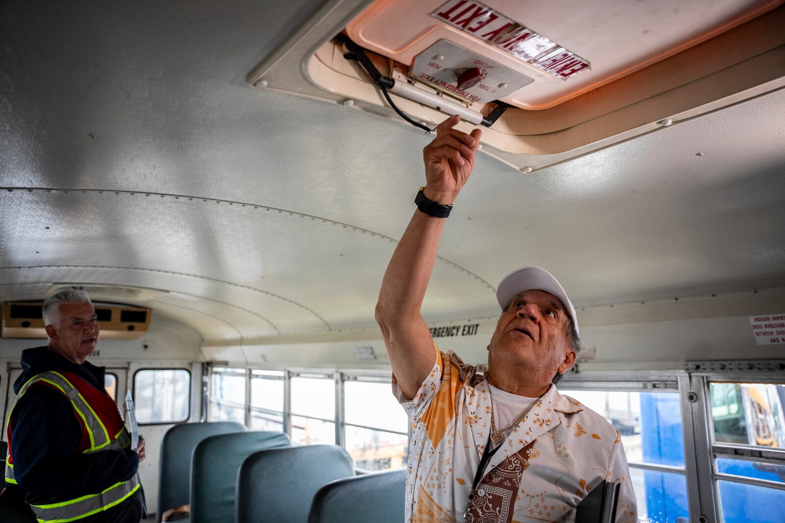 Manuel Castillo, right, one of the Spanish-speaking truck driving students, runs through a safety check with guidance from instructor Paul Cuartas on a training school bus at the Driving Academy on Tuesday, June 10, 2025 in Linden, N.J. (AP Photo/Angelina Katsanis)