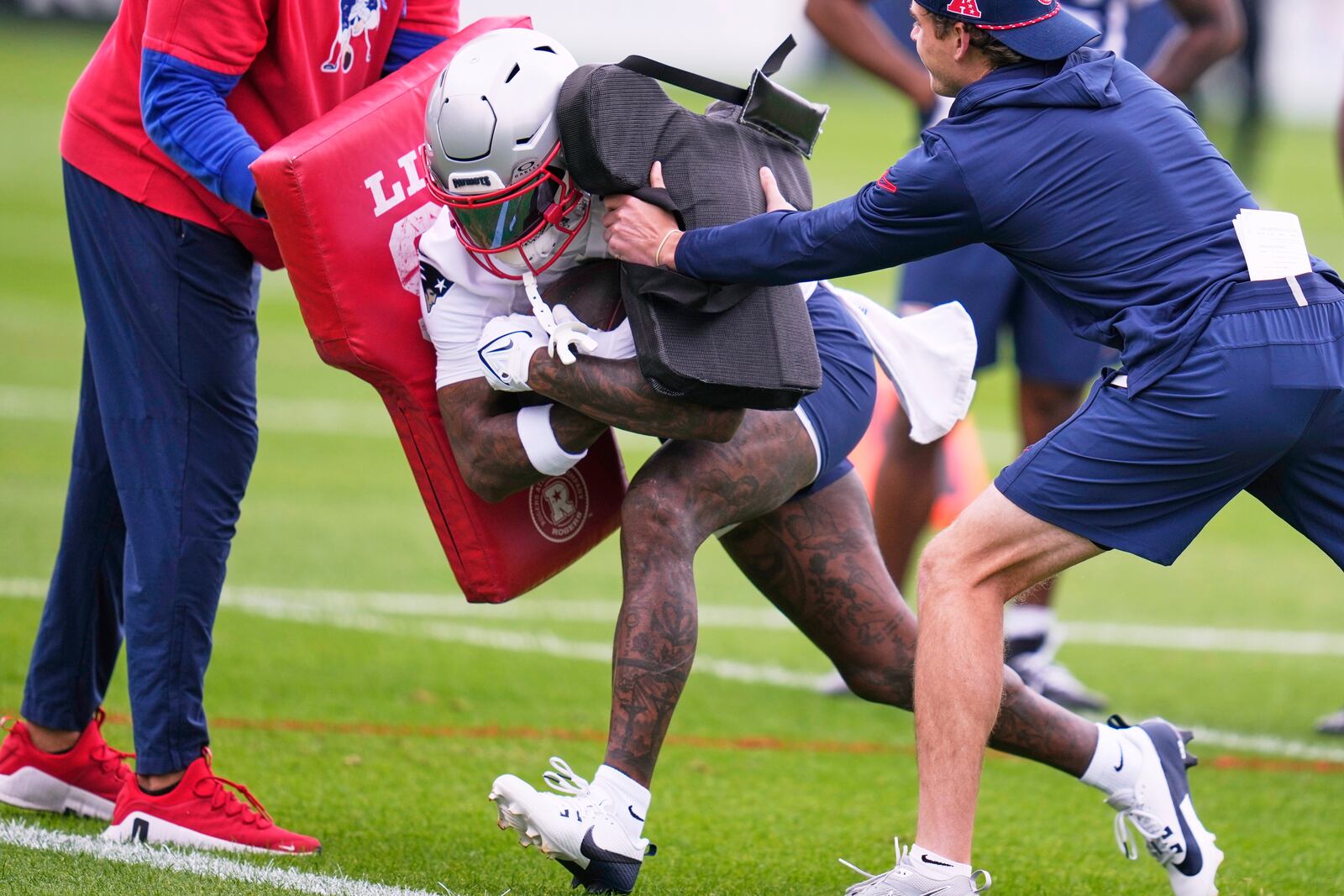 New England Patriots wide receiver Stefon Diggs is hit while running through blocking pads during an NFL football practice, Monday, June 9, 2025, in Foxborough, Mass. (AP Photo/Charles Krupa)
