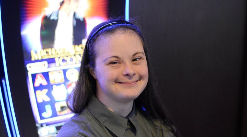 Kiersten Shelton, 24, of Fairfield, has worked at Miami Valley Gaming for about a year in housekeeping. She’s pictured in front of the Michael Jackson Icon slot machine on Thursday as Jackson is her favorite singer. Kiersten has Down syndrome and receives services through the Butler County Board of Developmental Disabilities, and was recommended for employment at the casino. MICHAEL D. PITMAN/STAFF