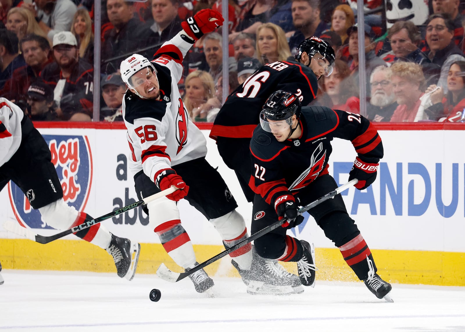 Carolina Hurricanes' Logan Stankoven (22) gathers in the puck around teammate Sean Walker (26) and in front of New Jersey Devils' Erik Haula (56) during the third period of Game 5 of an NHL hockey Stanley Cup first-round playoff series in Raleigh, N.C., Tuesday, April 29, 2025. (AP Photo/Karl DeBlaker)
