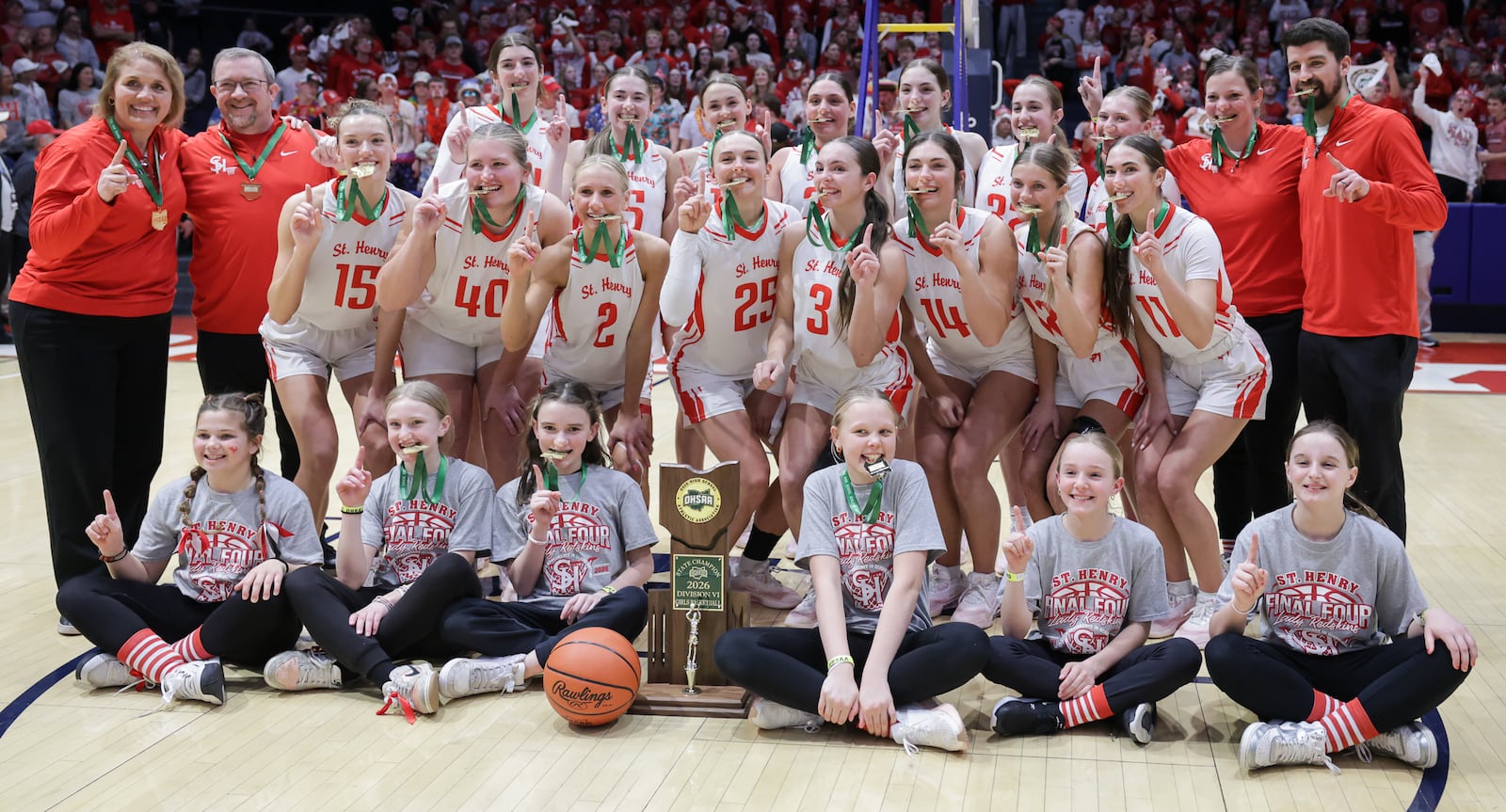 St. Henry players and coaches pose for a team photo after defeating Canton Central Catholic 53-34 in the Division VI state championship on Friday, March 13 at University of Dayton Arena. BRYANT BILLING / STAFF
