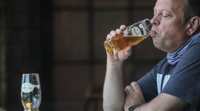 Marvin Most from Bellbrook enjoys a beer at Warped Wing Brewery on Wyandot Street Friday afternoon. House Bill 674, which now goes to the Senate for consideration, calls for making several changes to Ohio’s liquor laws as a means of helping bars and restaurants hit hard by the coronavirus shutdown. JIM NOELKER/STAFF