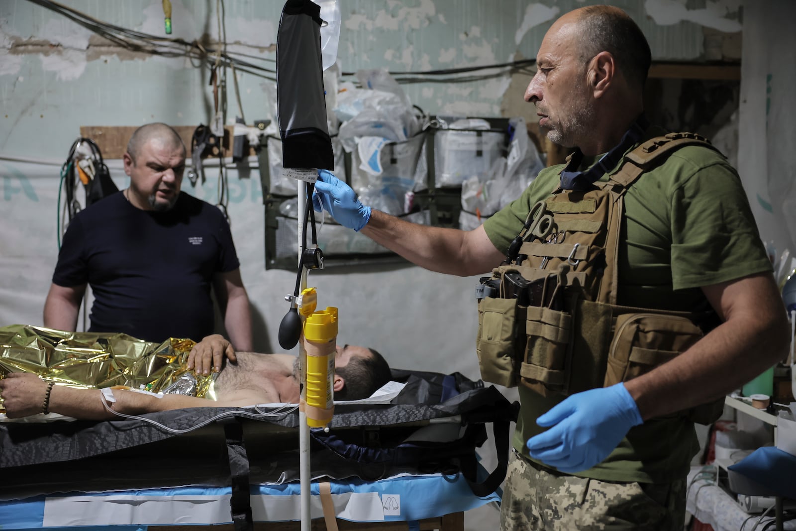 In this photo provided by Ukraine's 24th Mechanized Brigade press service, military medics give first aid to a wounded Ukrainian soldier at a medical stabilisation point in Donetsk region, Ukraine, Friday, July 25, 2025, (Oleg Petrasiuk/Ukraine's 24th Mechanized Brigade via AP)