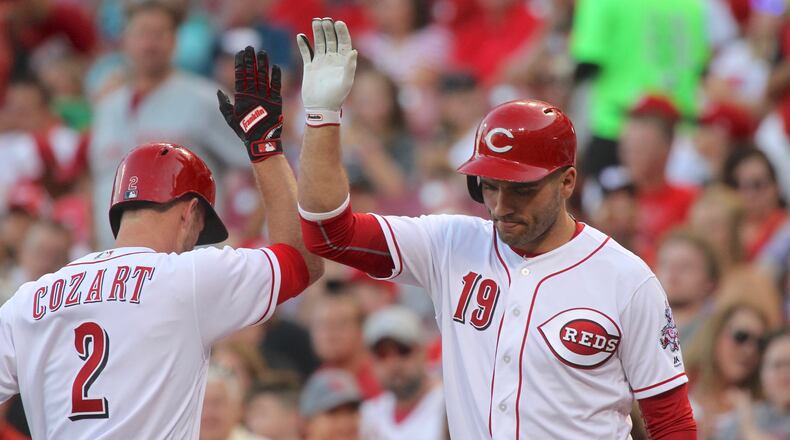 The Reds’ Zack Cozart, left, slaps hands with Joey Votto after hitting a home run against the Diamondbacks on Wednesday, July 19, 2017, at Great American Ball Park in Cincinnati. David Jablonski/Staff