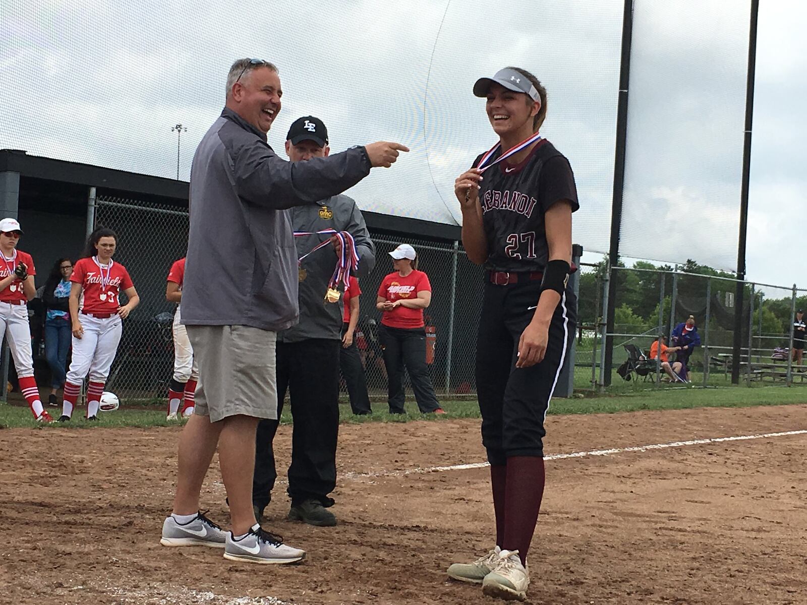 Lebanon coach Brian Kindell and LHS senior Madison Hartman share a laugh during the awards ceremony after Saturday’s 5-1 victory over Fairfield in a Division I district final at Lakota East. Helping with the awards is East athletic director Rich Bryant. RICK CASSANO/STAFF