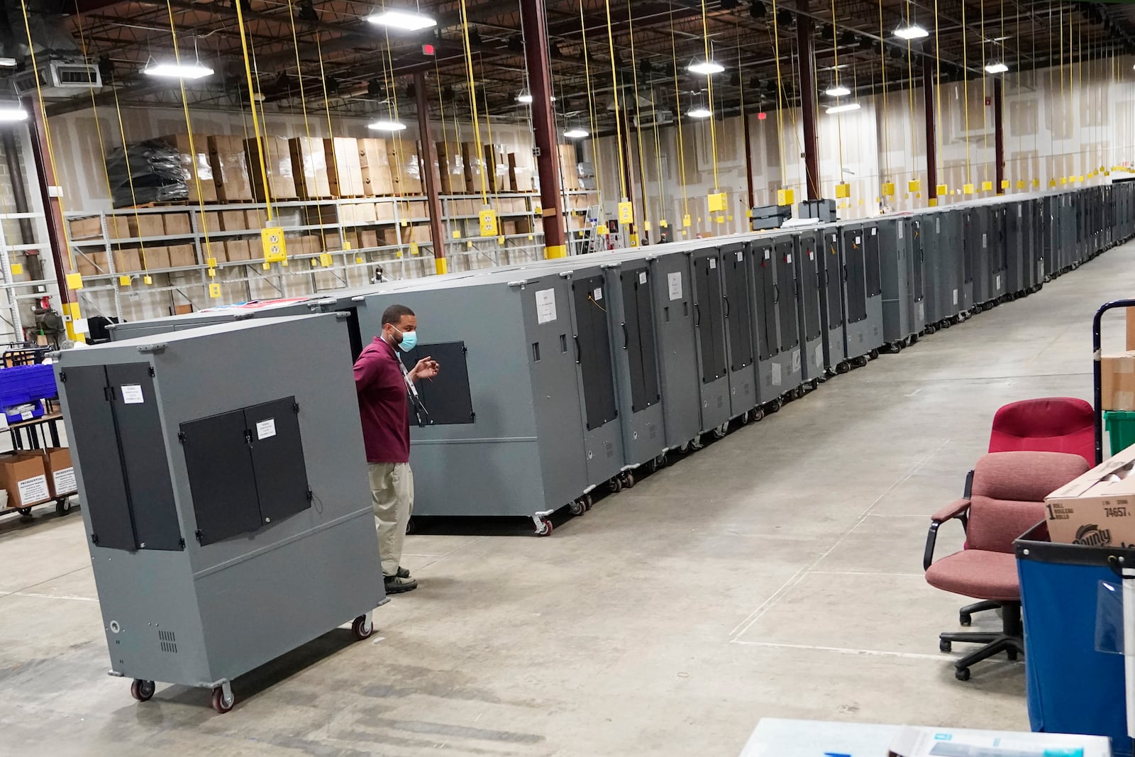 FILE - A worker returns voting machines to storage at the Fulton County Election preparation Center Nov. 4, 2020, in Atlanta. (AP Photo/John Bazemore, File)