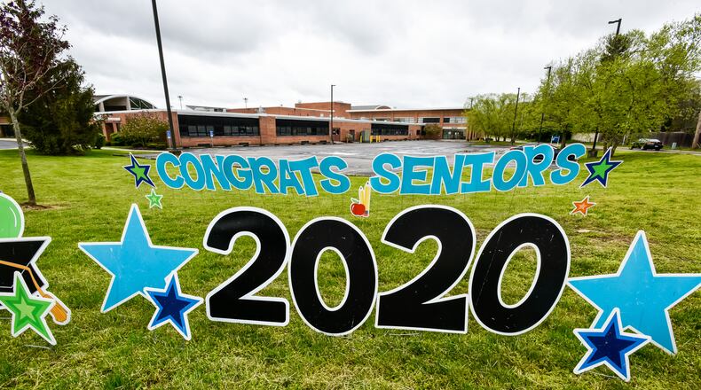 Hamilton High School seniors picked up their caps and gowns Thursday, April 30, 2020 at Hamilton High School in Hamilton. The seniors and parents were greeted by signs drove through balloon arches as they picked up their graduation supplies in drive-thru fashion. Schools around the area are still trying to figure out how to make graduations ceremonies special for students while keeping with the social distancing guidelines. Hamilton has not announced their plans yet for graduation. NICK GRAHAM / STAFF