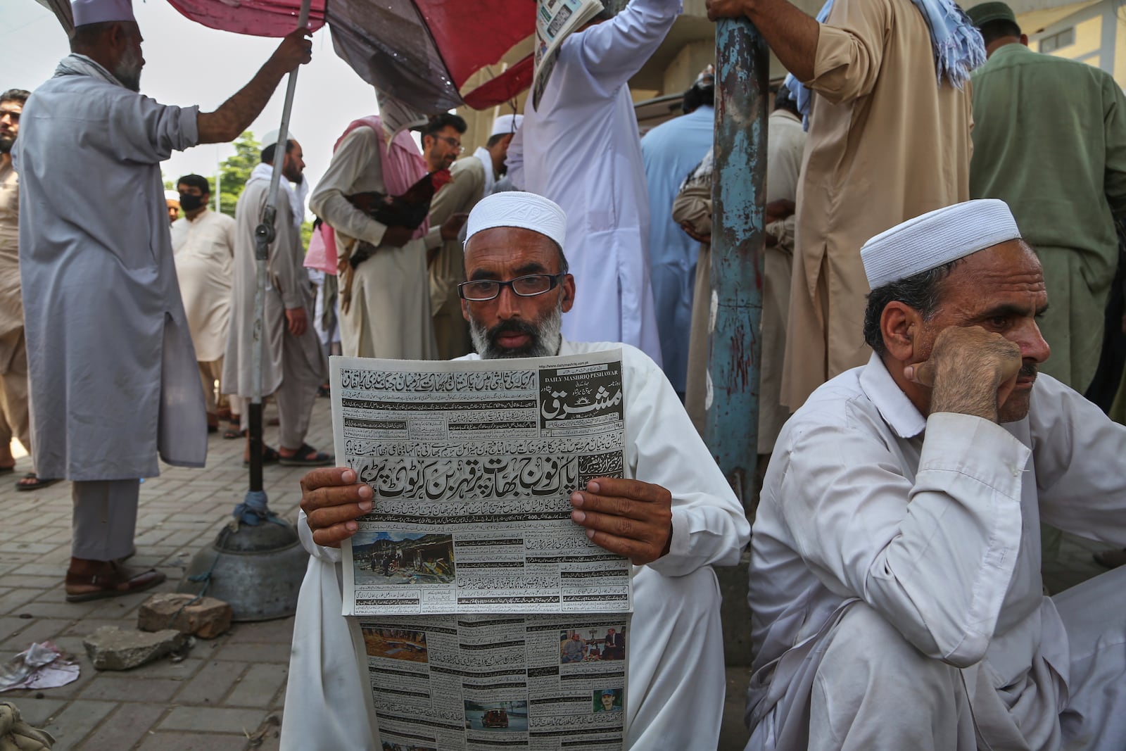 A Pakistani reads a morning newspaper at a stall, a day after the ceasefire between Indian and Pakistan was announced, in Peshawar, Pakistan, Sunday, May 11, 2025. (AP Photo/Muhammad Sajjad)