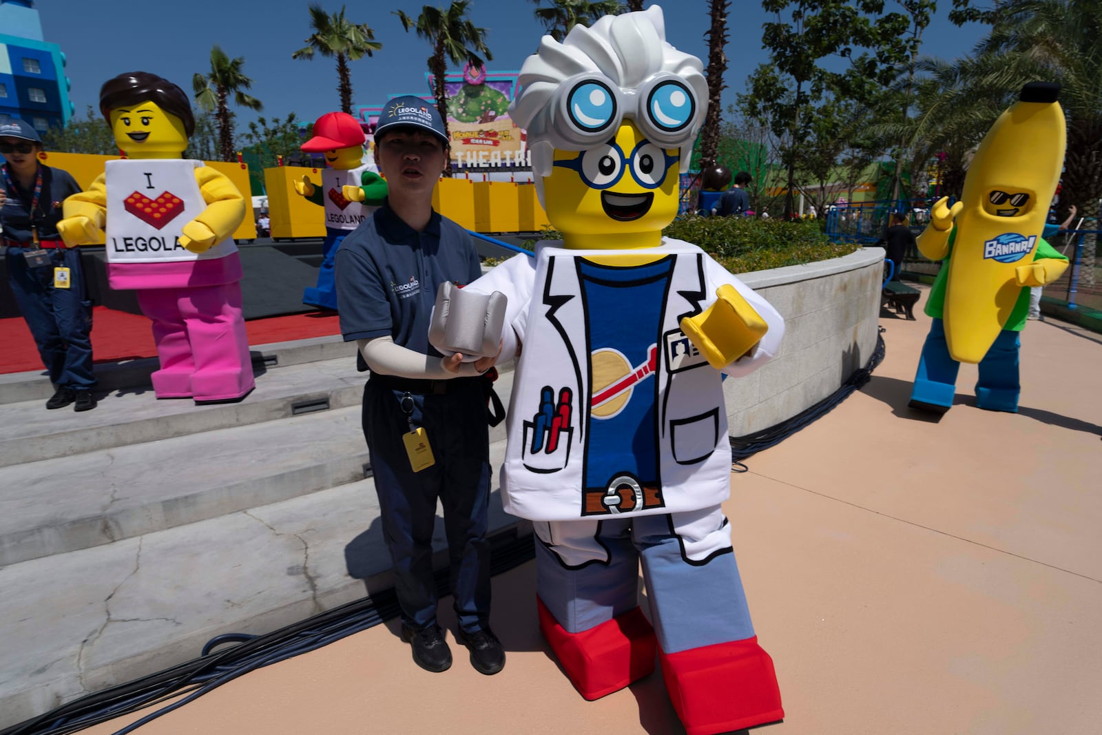 Workers guide Lego mascot characters during the opening of Legoland Shanghai, China's first and the world's largest Legoland resort, in Shanghai, Saturday, July 5, 2025. (AP Photo/Ng Han Guan)