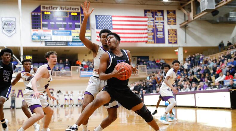 Cincinnati Christian’s Devin McKinnon spins past Emmanuel Christian Academy’s Fred Shropshire during their Division IV district final game on Friday night at the Vandalia Butler Student Activity Center. CONTRIBUTED PHOTO BY MICHAEL COOPER