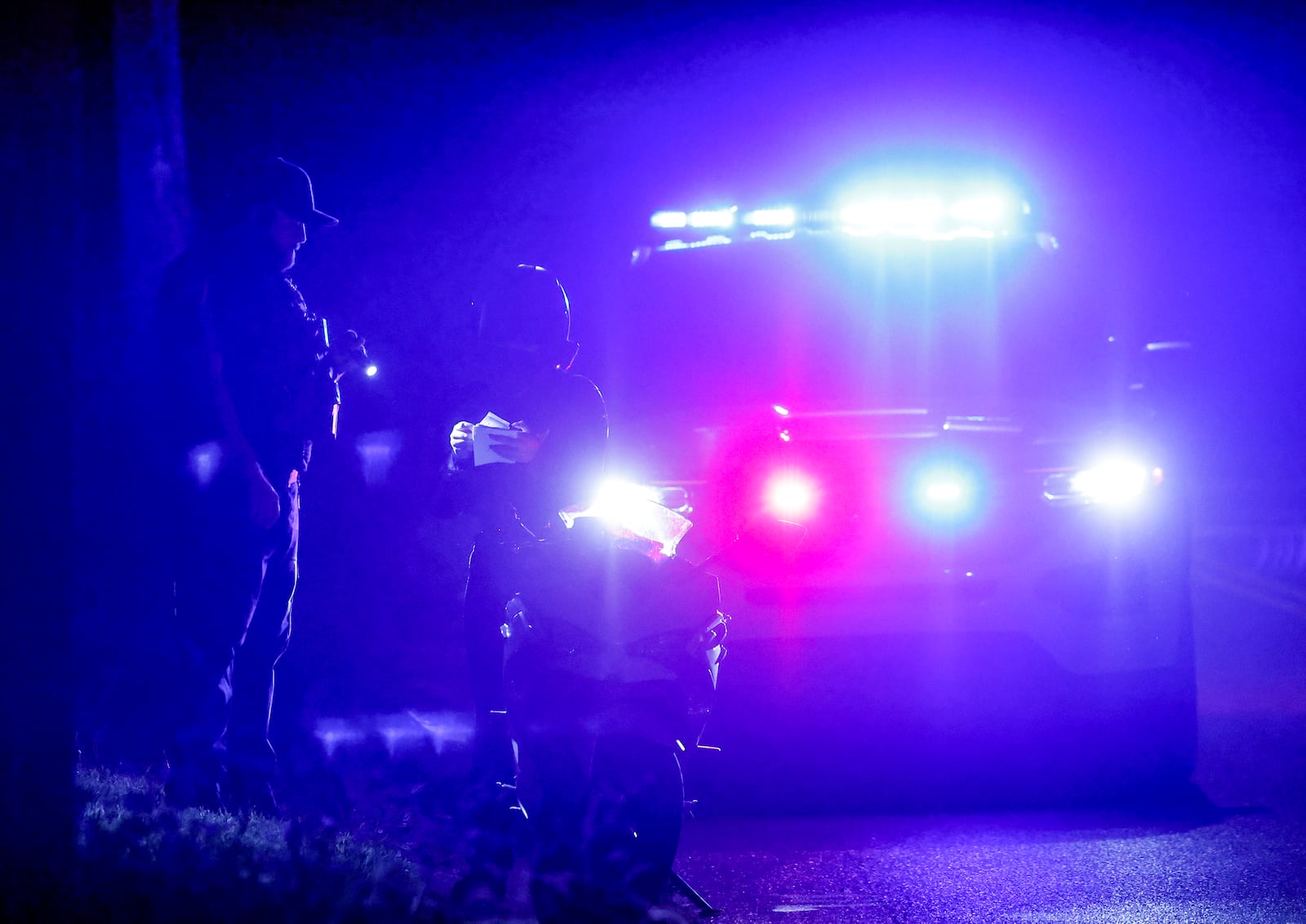 A motorcyclist is pulled over by police as car enthusiasts cruise in a nearby parking lot Saturday night in Middletown. NICK GRAHAM/STAFF