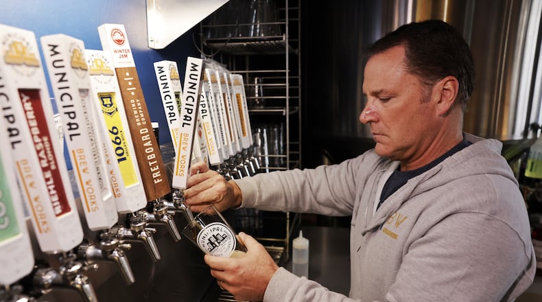 Co-owner Jim Goodman pours a beer at Municipal Brew Works in Hamilton. NICK GRAHAM/STAFF