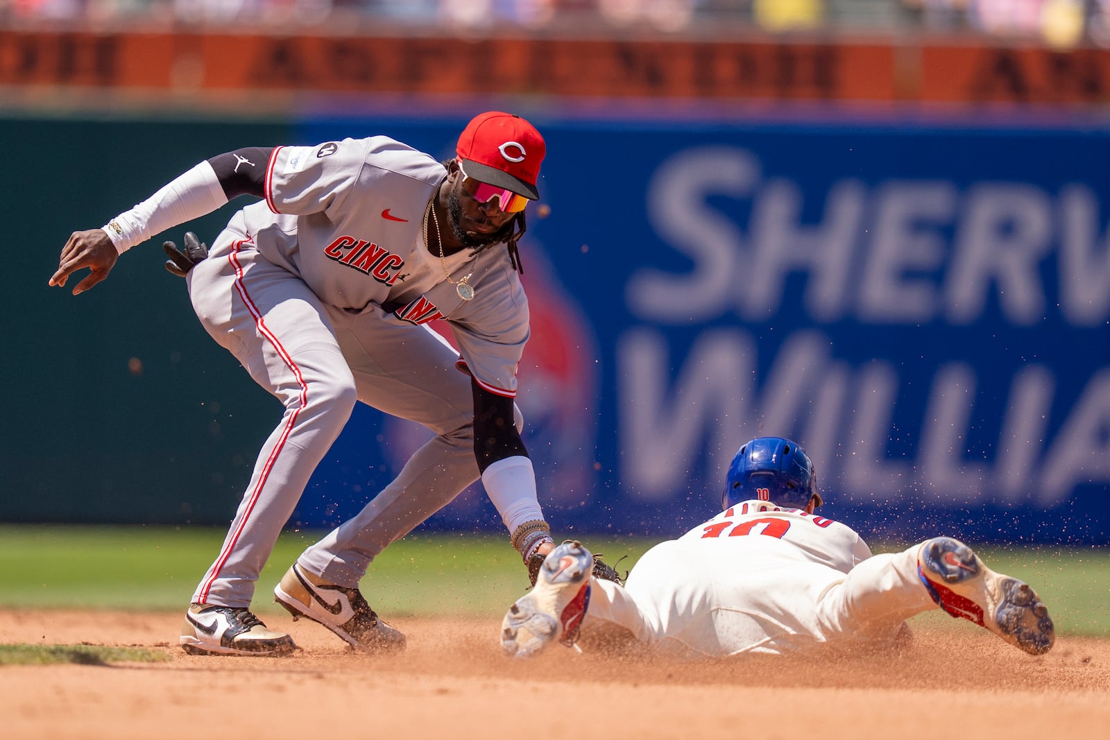 Cincinnati Reds shortstop Elly De La Cruz, left, catches Philadelphia Phillies' J.T. Realmuto, right, stealing during the fourth inning of a baseball game, Sunday, July 6, 2025, in Philadelphia. (AP Photo/Chris Szagola)
