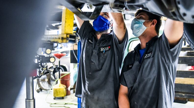 Nathan Sweetland. left, and Erik Rumpke work on a truck at Rose Automotive in Hamilton. NICK GRAHAM / STAFF