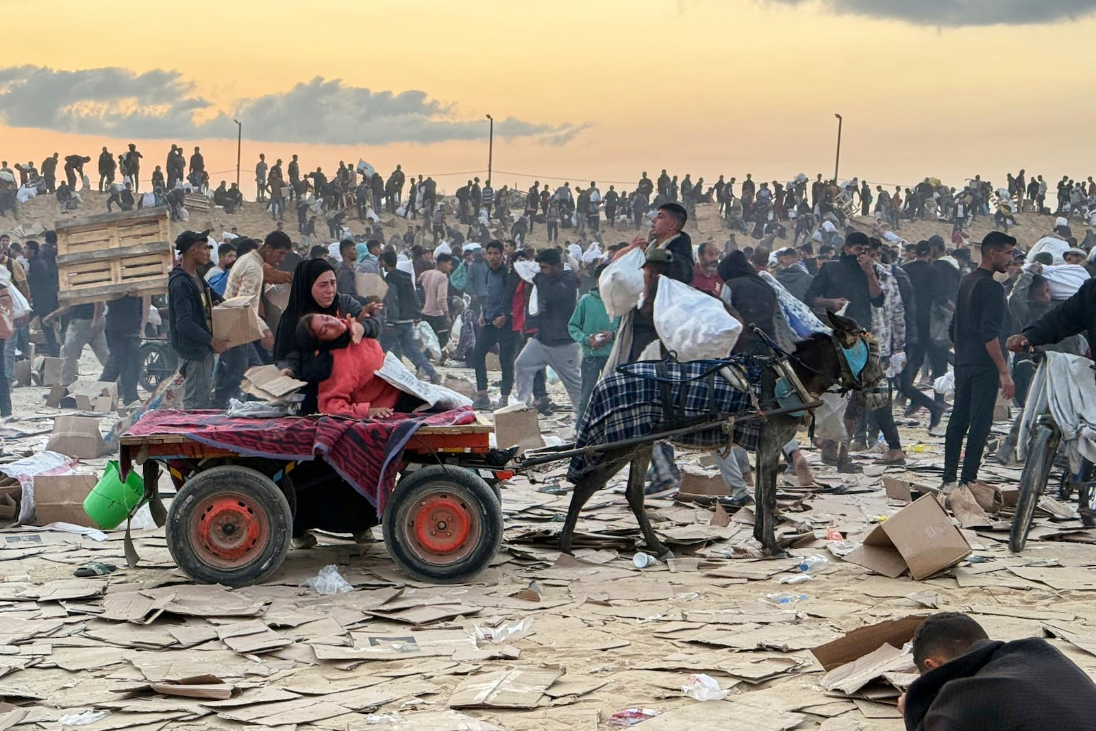 This photo, provided by an American contractor on condition of anonymity, shows a woman slumped over in a donkey cart after the contractor said she was hit in the head with part of a stun grenade at a food distribution site in Gaza run by the Gaza Humanitarian Foundation in June 2025. (AP Photo)