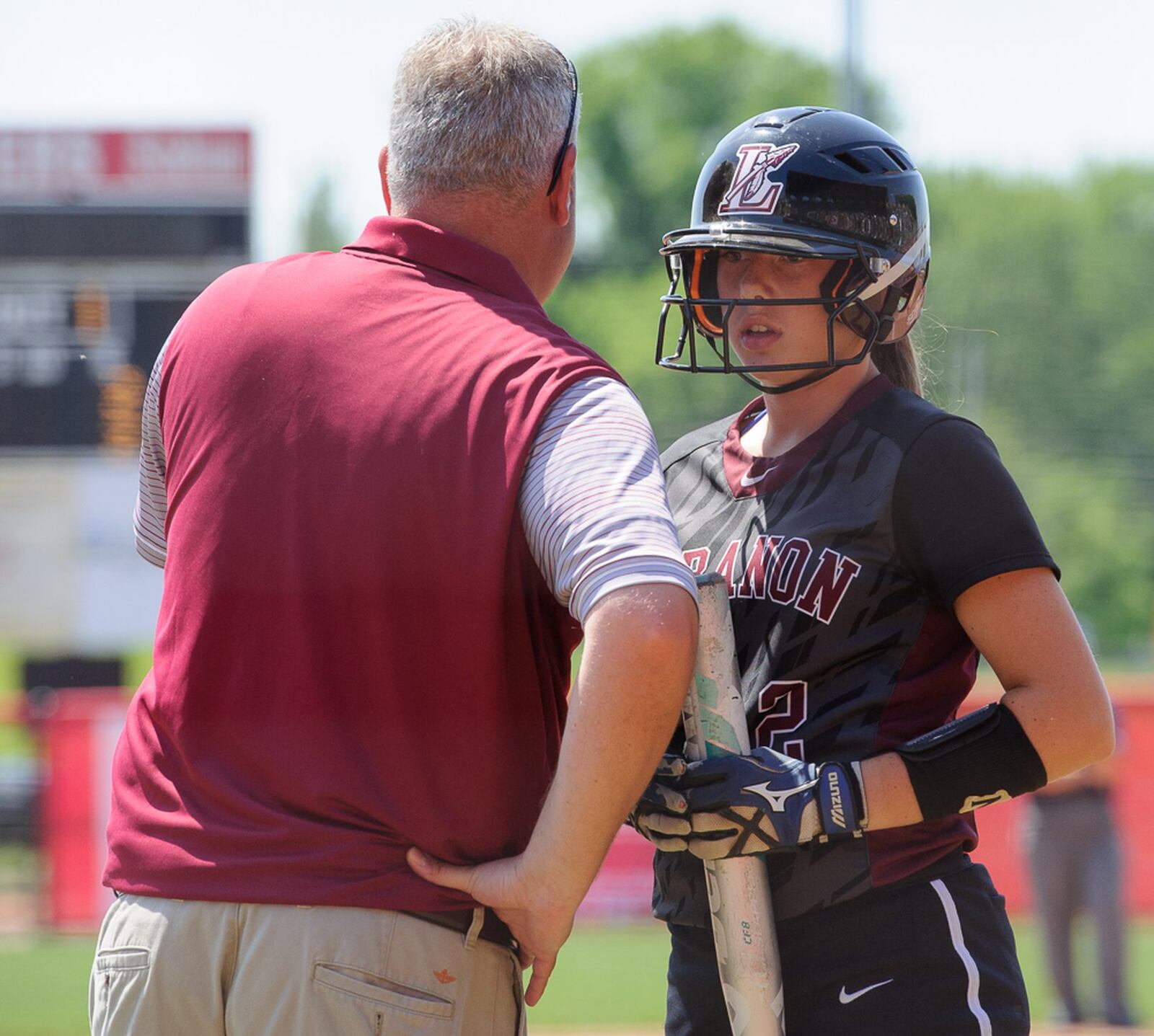 Lebanon sophomore Kat Frank (right) listens to instructions from coach Brian Kindell in the seventh inning of the Division I state final June 3 at Firestone Stadium in Akron. CONTRIBUTED PHOTO BY BRYANT BILLING