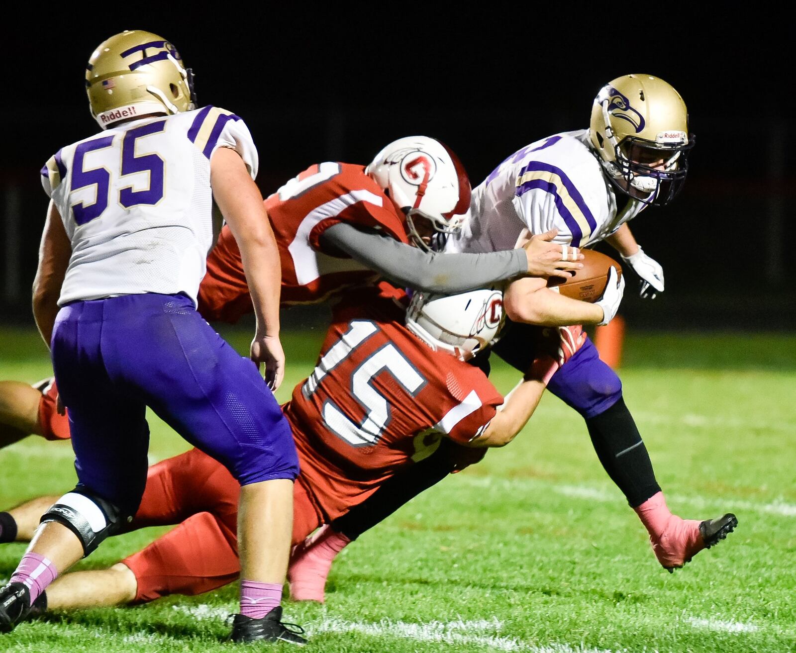 Eaton’s Caleb Puckett (42) is brought down by Carlisle’s Dakota Milligan (15) and Braden Rauch (12) during Thursday night’s game at Laughlin Field in Carlisle. NICK GRAHAM/STAFF