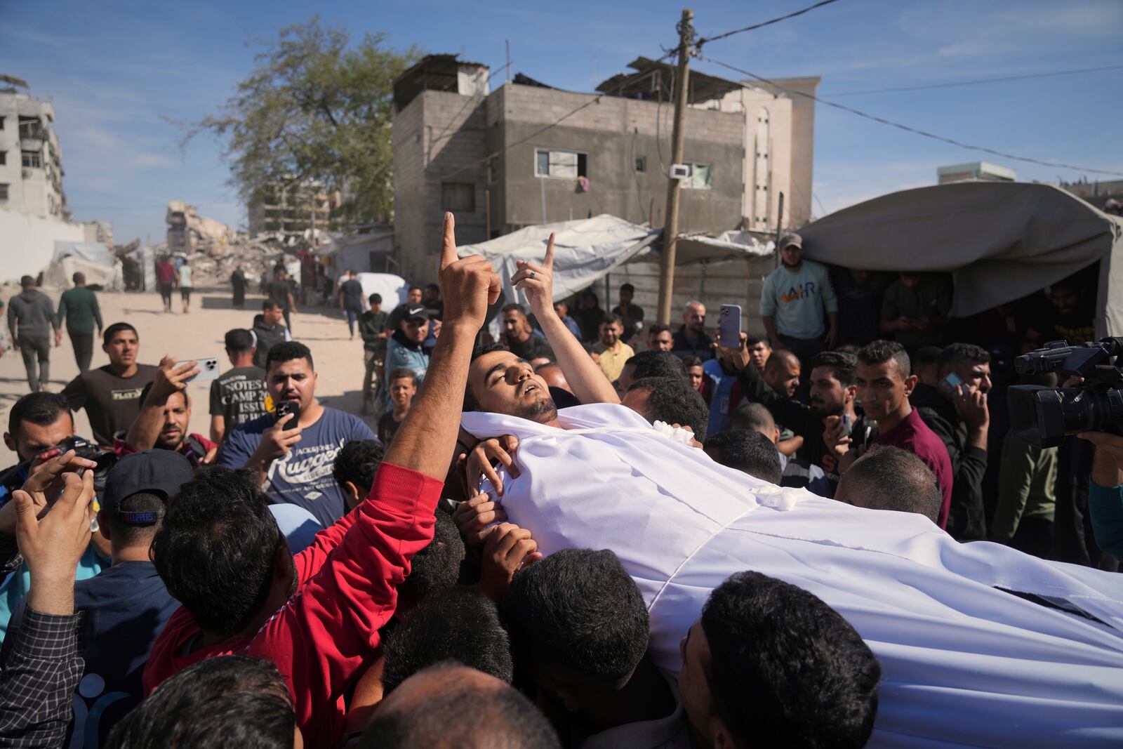 The body of man who was killed along with at least 28 others in an Israeli army strike on a restaurant, is carried for burial at Shifa hospital in Gaza City, Wednesday, May 7, 2025.