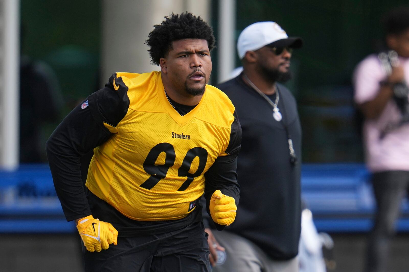 Pittsburgh Steelers head coach Mike Tomlin, right, watches as first round draft pick Derrick Harmon (99) warms up during the during the NFL football team's rookie camp in Pittsburgh, Friday, May 9, 2025. (AP Photo/Gene J. Puskar)