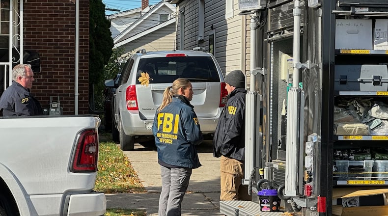 FBI agents gather outside a home in a Dearborn, Mich., neighborhood on Friday, Oct. 31, 2025. (AP Photo/Mike Householder)