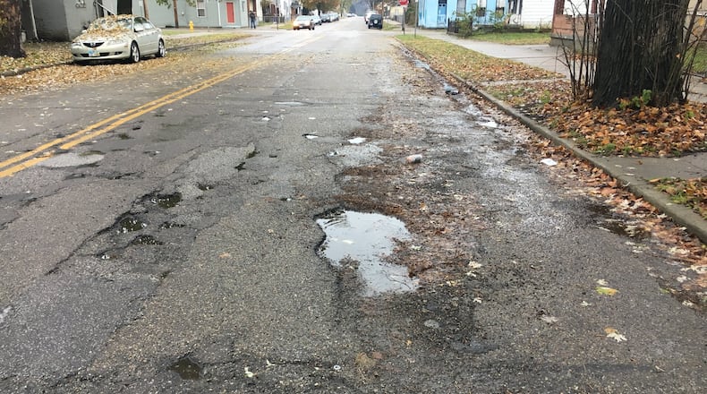 Plentiful potholes can be seen on Ludlow Street in Hamilton. City residents in May will be asked to approve a street-repair levy to help eliminate the problem.