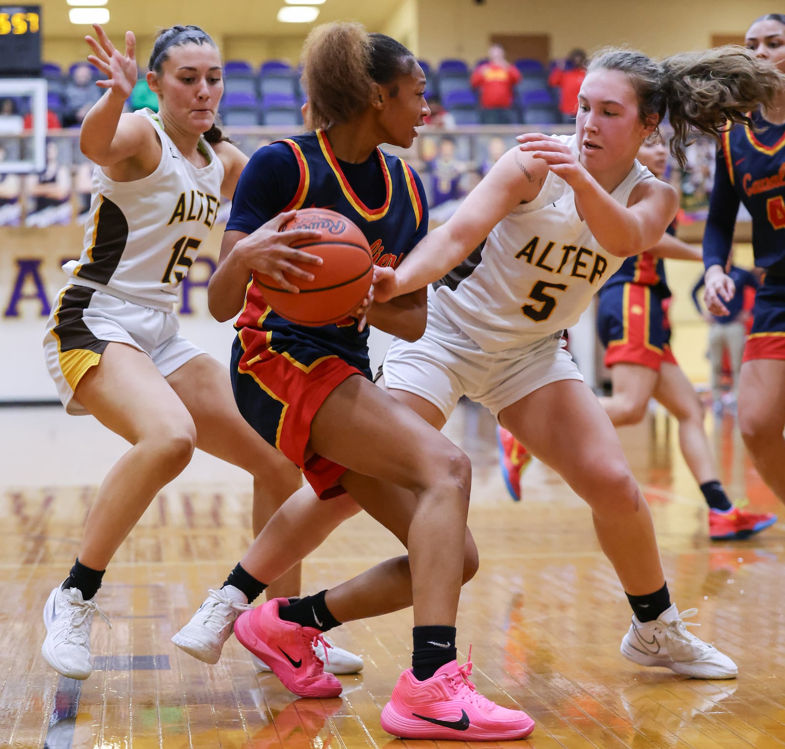 Alter senior forward Samantha Pothast (left) and senior guard Alina Overman (right) guard Cincinnati Purcell Marian's Lauryn Brown during a Division IV regional final on Saturday, March 7 at Vandalia-Butler's Student Activity Center. BRYANT BILLING / STAFF