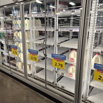 The milk shelves at the Springboro Kroger were empty Thursday and people stocked up before Saturday's forecasted large snow storm. Michael Kurtz / Staff