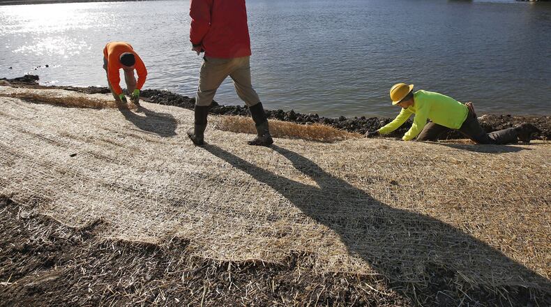 The removal of the Tait Station low dam on the Great Miami River has been completed, according to the Miami Conservancy District. Workers from Cardno Environmental Management were completing reconstruction of the banks on Wednesday with a native seed mix and blanketing to hold the seeds in place. TY GREENLEES / STAFF