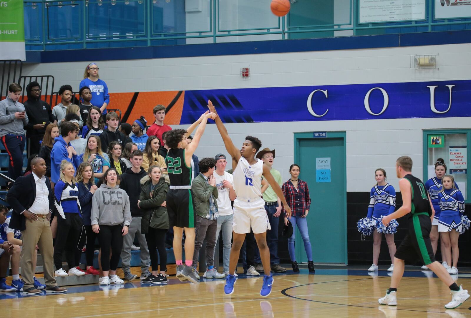 New Miami’s Jordan Robinette (22) fires a 3-pointer over Cincinnati Christian’s Devin McKinnon during Tuesday night’s game at CCS. The host Cougars won 54-37. PHOTO BY KRAE/WWW.KRAEPHOTOGRAPHY.COM