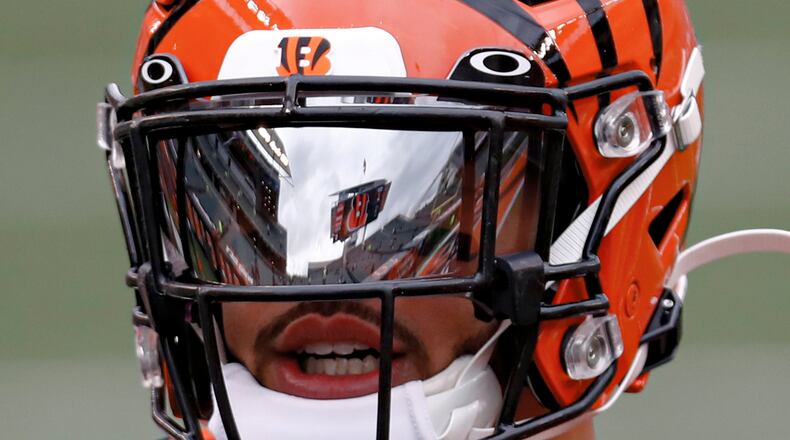 The scoreboard and seating area of Paul Brown Stadium are reflected in the visor of Cincinnati Bengals free safety Jessie Bates (30) as he warms up before an NFL football game against the Baltimore Ravens, Sunday, Jan. 3, 2021, in Cincinnati. (AP Photo/Aaron Doster)