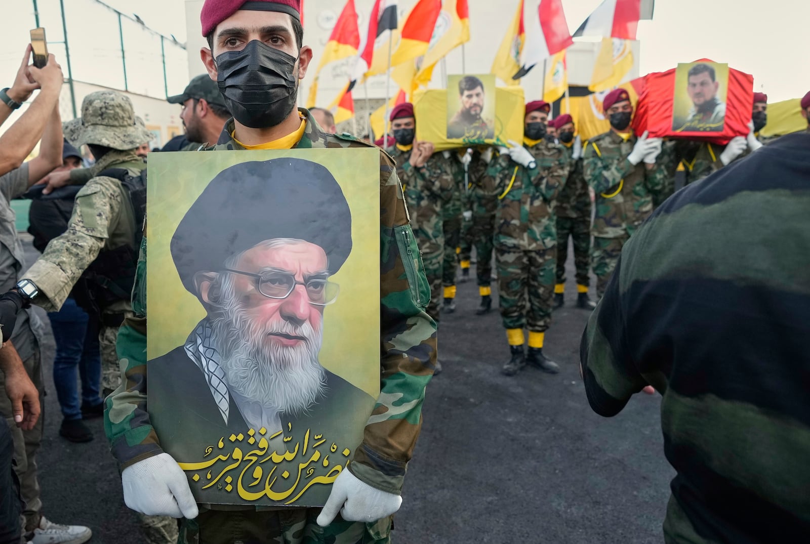 Members from the Popular Mobilization Forces carrying the coffins of Iraqi commander Haider al-Moussawi from Kataeb Sayyed Al-Shuhada and Hussein Khalil, a former aide to the late Hezbollah Secretary-General Hassan Nasrallah that killed by an Israeli airstrike inside Iran, in Baghdad, Iraq, Sunday, June 22, 2025. (AP Photo/Hadi Mizban)