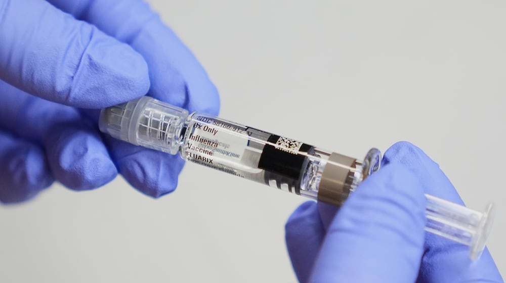 FILE - A certified medical assistant holds a syringe for a flu vaccine at a clinic in Seattle, on Wednesday, Sept. 10, 2025. (AP Photo/Lindsey Wasson, File)