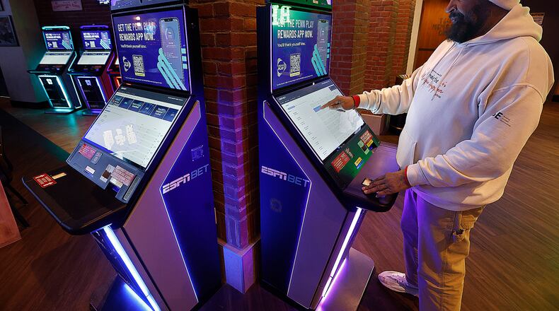 Antonio Ford places a bet at a sports betting kiosk at Hollywood Gaming at Dayton Raceway Friday, Feb. 28, 2025. Ohioans bet almost $8.9 billion on sports in 2024, which was 15.9% more than the nearly $7.7 billion they bet in 2023. MARSHALL GORBY/STAFF
