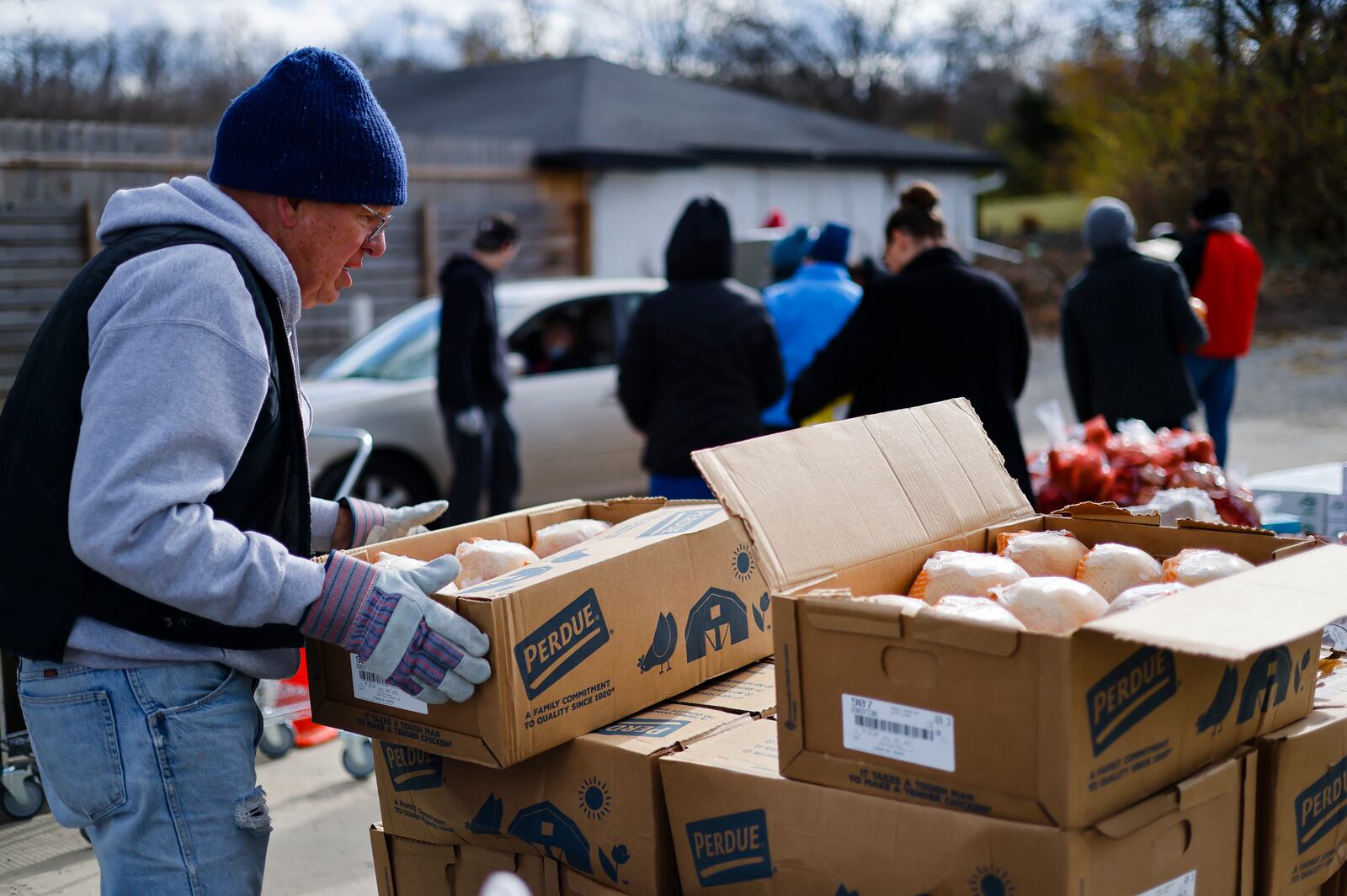 Volunteer Virgil Siefker moves food for distribution. Volunteers and employees at Shared Harvest food Bank distribute food for around 250 families Friday, Nov. 18, 2022 in Fairfield. NICK GRAHAM/STAFF