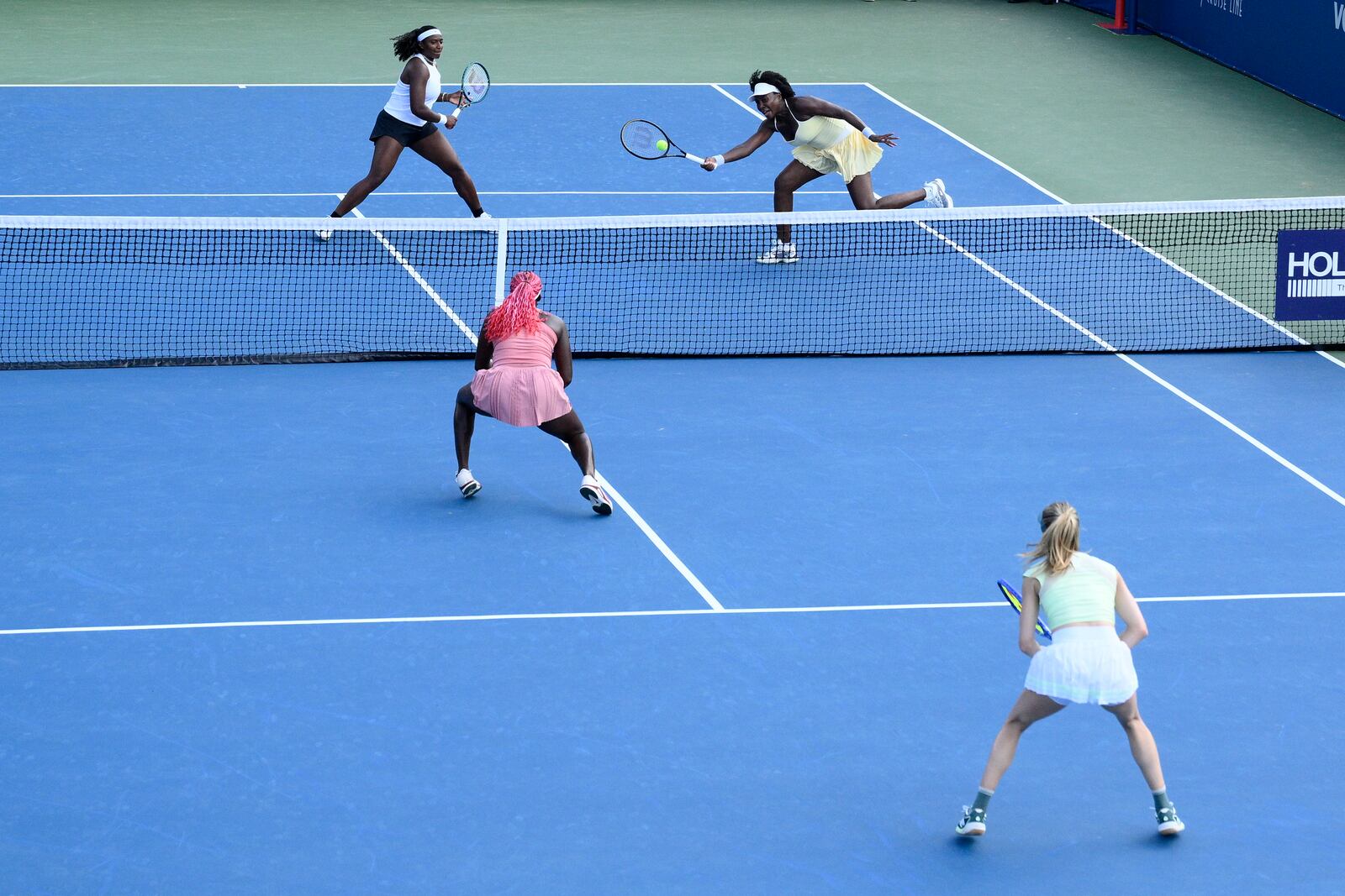 Hailey Baptiste, top left, and Venus Williams top right, compete during a doubles match against Eugenie Bouchard, bottom right, and Clervie Ngounoue, bottom left, at the Citi Open tennis tournament Monday, July 21, 2025, in Washington. (AP Photo/Nick Wass)