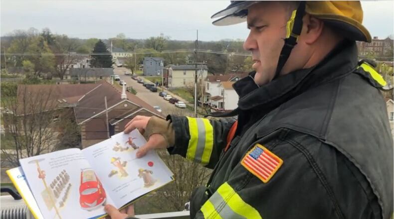 Hamilton Firefighter Matt Hughes reads to children virtually from the Tower 22 Bucket Rtuck. PROVIDED