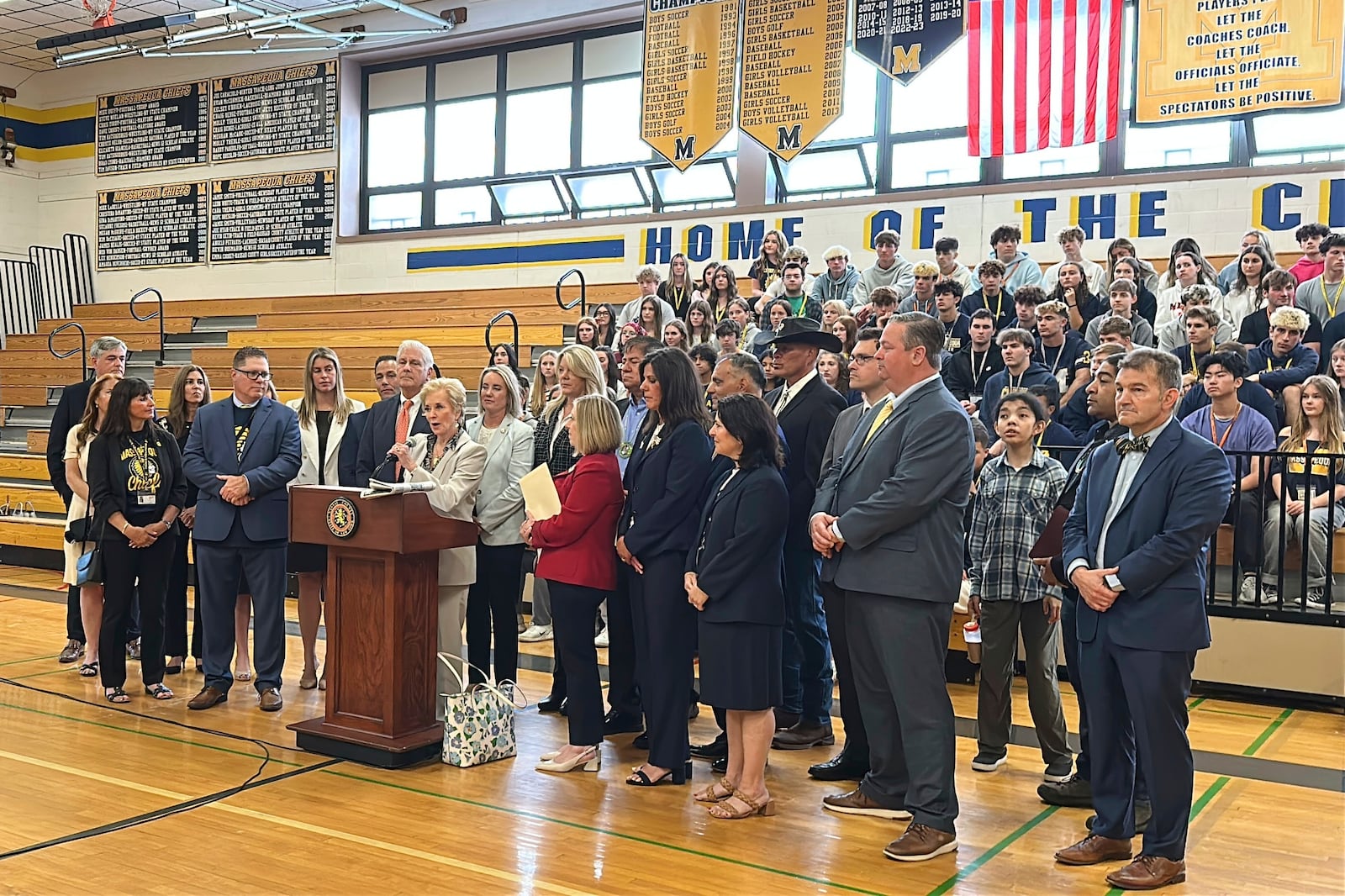 U.S. Secretary of Education Linda McMahon, at dais, speaks during a visit to Massapequa High School, Friday, May 30, 2025, in Massapequa, N.Y., along with local elected officials. (AP Photo/Philip Marcelo)
