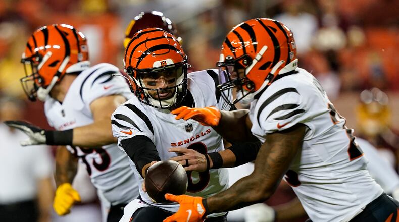 Cincinnati Bengals quarterback Brandon Allen (8) hands off the ball to running back Joe Mixon, right, during the first half of a preseason NFL football game against the Washington Football Team, Friday, Aug. 20, 2021, in Landover, Md. (AP Photo/Susan Walsh)