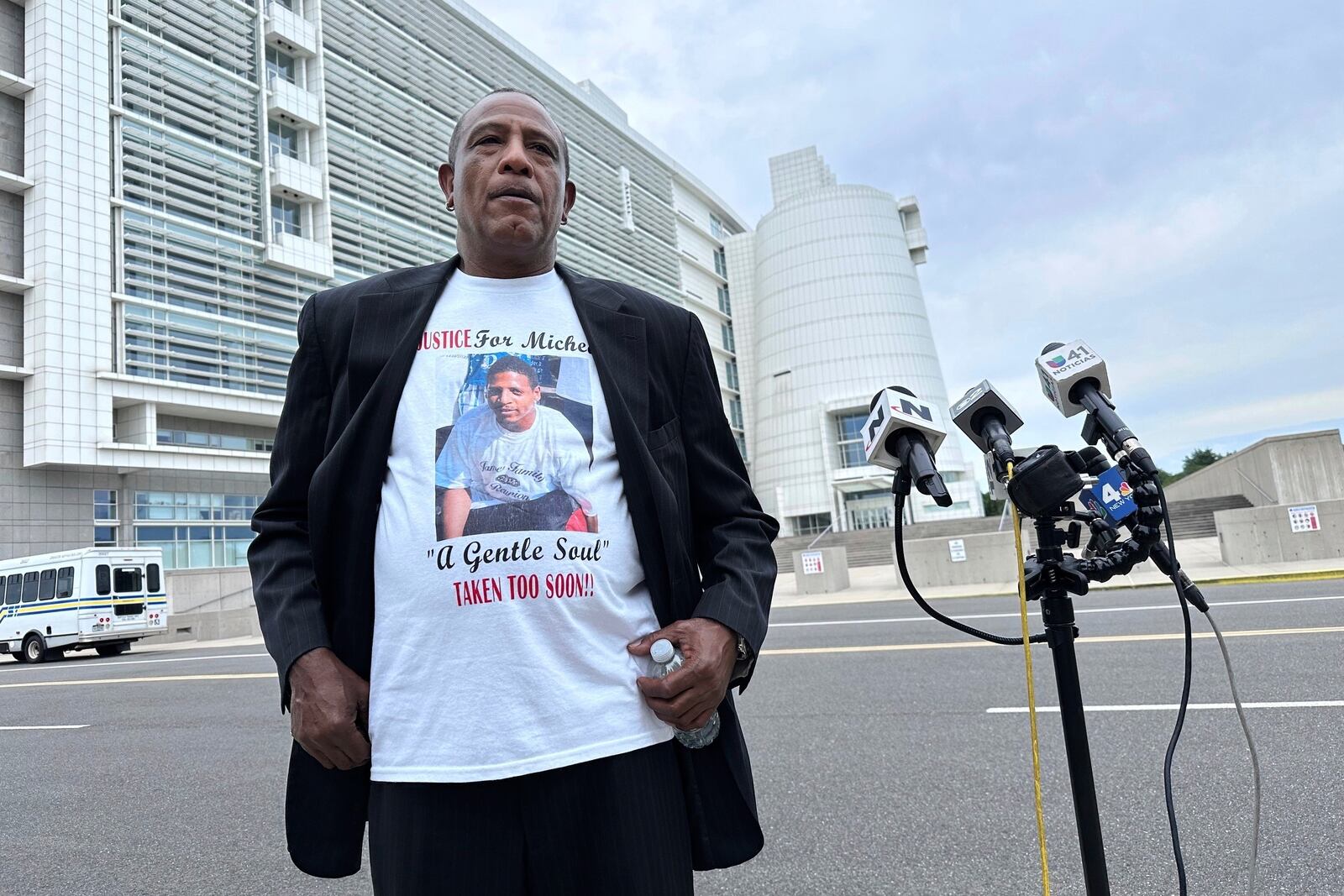 George Johnson stands outside federal court in Central Islip, N.Y. on Wednesday, July 2, 2025 wearing a shirt bearing an image of his son, Michael Johnson, who was slain by MS-13 gang members in 2016. (AP Photo/Philip Marcelo)