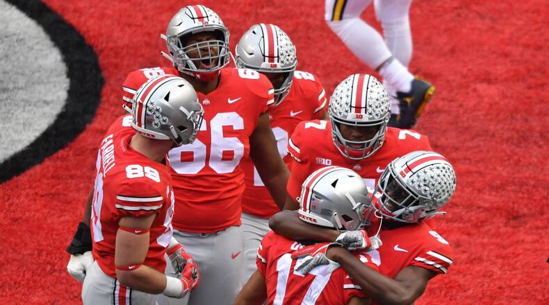 COLUMBUS, OH - NOVEMBER 24: The Ohio State Buckeyes celebrate with Chris Olave #17 of the Ohio State Buckeyes after a first quarter touchdown against the Michigan Wolverines at Ohio Stadium on November 24, 2018 in Columbus, Ohio. (Photo by Jamie Sabau/Getty Images)