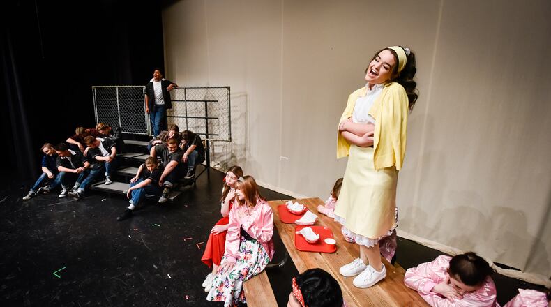 Faith Auvil, playing the role of Sandy, and Evan Crim, playing the role of Danny, stand among the Madison Thespians as they rehearse for the musical "Grease" Tuesday, April 16 at Madison Jr.-Sr. High School in Madison Township. Grease runs April 25 through April 28, 2019 in the school theater. Tickets are available at madisonarts.org or order forms are available at the high school front office. NICK GRAHAM/STAFF