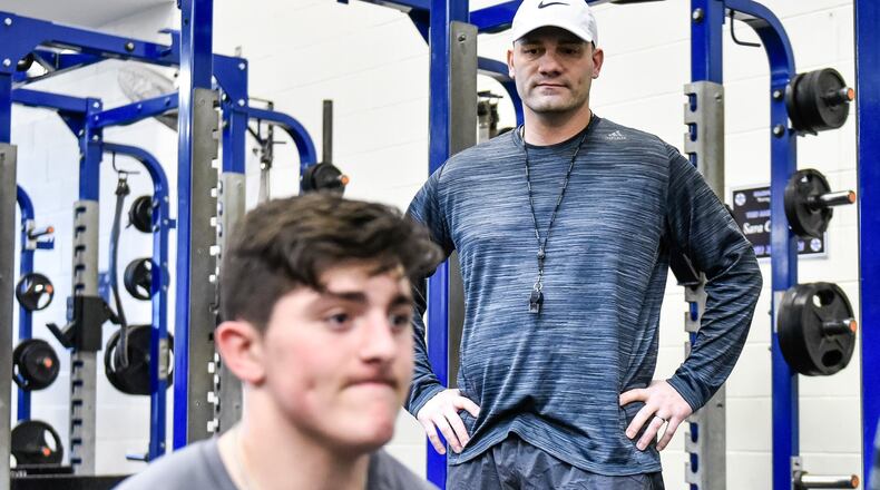 New Hamilton football coach Nate Mahon keeps his eyes on a Big Blue weight lifting session Thursday at the school. NICK GRAHAM/STAFF