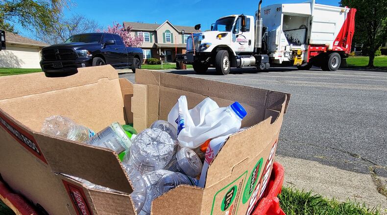 Rumpke employee Michael McDonald collects recyclable materials during his route Friday, April 16, 2021 in West Chester Twp. NICK GRAHAM / STAFF