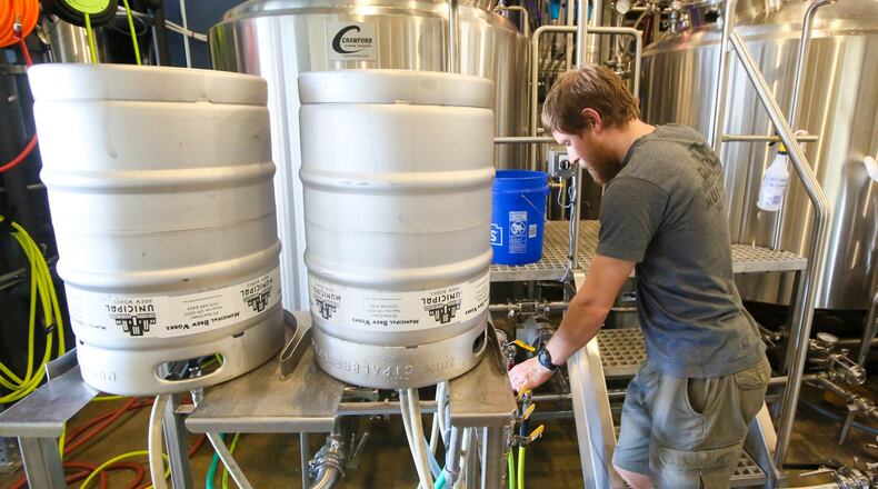 Municipal Brew Works brewer Andrew Jarvi works with the tanks at the brewery on March 9. Municipal Brew Works has signed a distribution agreement with Ohio Eagle, which means the local brewery will have a wider distribution of its products. GREG LYNCH / STAFF