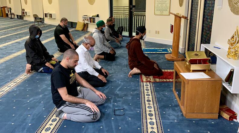 Men at Dayton Mercy Society Mosque in Miamisburg participate in evening prayer. Muslims pray five times each day. Dr. Abdul Wase (white shirt) said that if more Americans were to visit mosques and get to know Muslims, they would realize it is a peaceful religion.