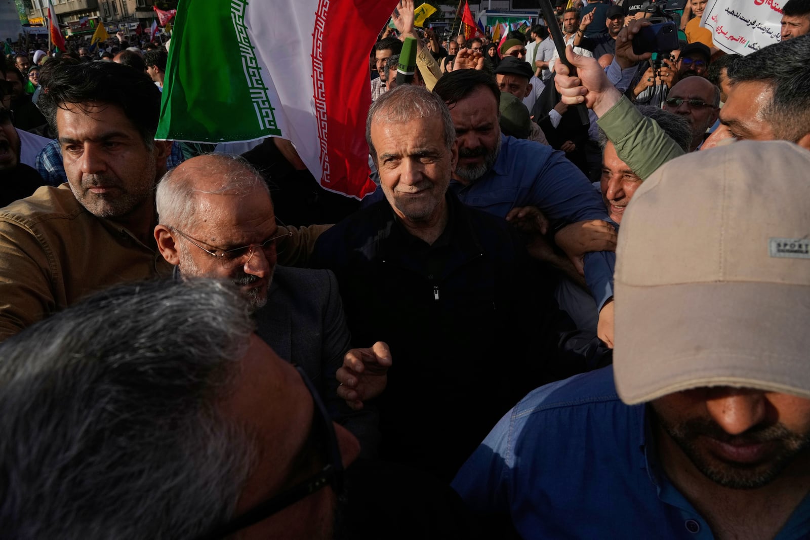 Iranian President Masoud Pezeshkian, center, attends a protest following the U.S. attacks on nuclear sites in Iran, in Tehran, Iran, Sunday, June 22, 2025. (AP Photo/Vahid Salemi)