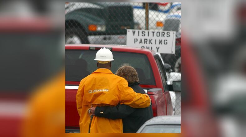 Security guards for Watkins Motor Lines in West Chester hug outside the trucking docks on Nov. 6, 2003, after two people were killed and three others injured in a shooting rampage. TY GREENLEES / STAFF FILE PHOTO