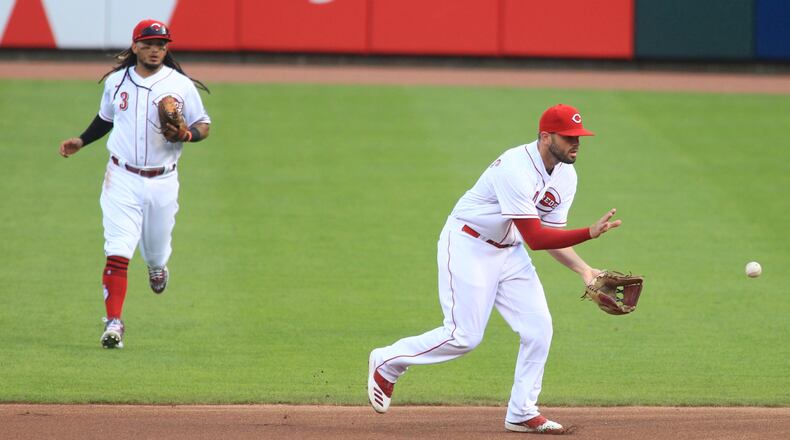 Reds second baseman Mike Moustakas fields a ball against the Tigers on Opening Day on Friday, July 24, 2020, at Great American Ball Park in Cincinnati. David Jablonski/Staff