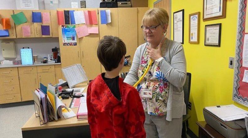 Fairfield Schools Lead Nurse Pam Buehler, seen here tending to a sick student, is among the many local school nurses now being lauded for their hard work during the initial school year - 2020 and beyond - after the onset of the COVID-19 pandemic. State and local school officials say the nurses were heroes in keeping thousands of students and school staffers safe during the deadlier days of the now fading pandemic. CONTRIBUTED